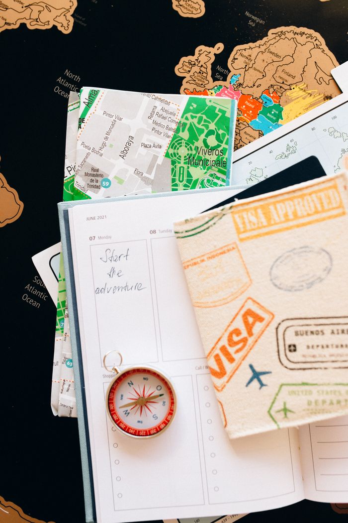 The Art of Drawing Readers In: Your attractive post title goes here Flat lay of travel essentials including compass, notebook, and map for a journey.